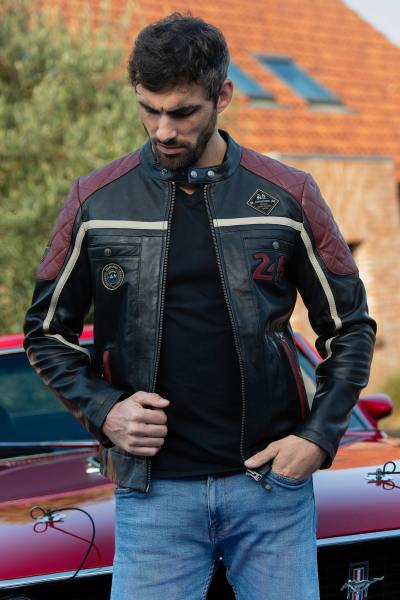 Chaqueta de cuero negra con inserciones rojas y hombros acolchados.