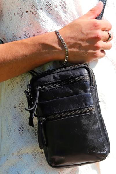 Bolso bandolera de piel negra con logotipo grabado en relieve
